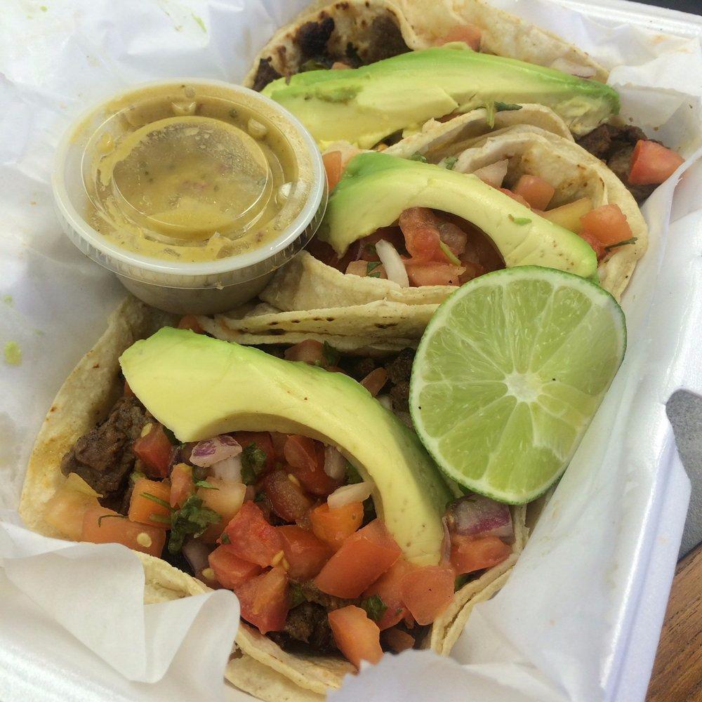 Takeout tray of steak tacos with avocado and lime from Masa Luna
